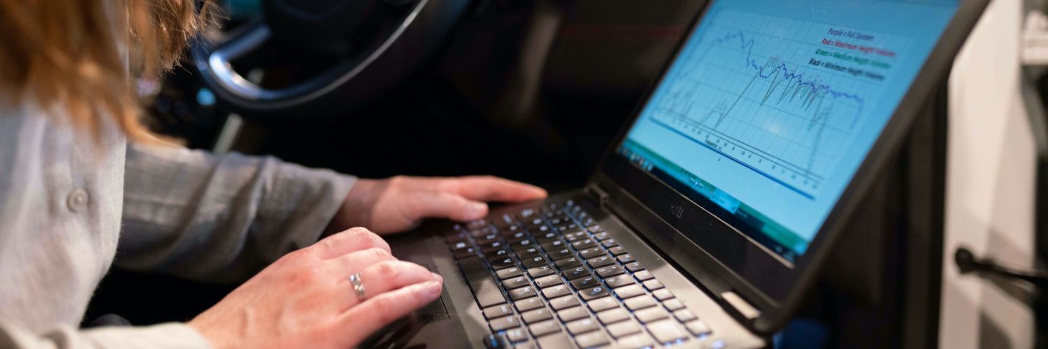close up of a woman typing on a laptop in car for stage chiptuning